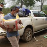 東ティモールの洪水被害の中支援物資を運ぶ人
