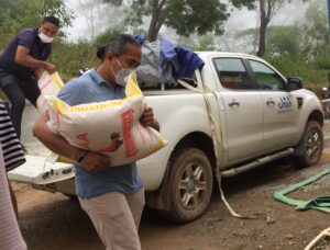 東ティモールの洪水被害の中支援物資を運ぶ人